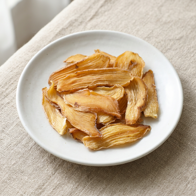 花姿盛无硫天麻特写，白瓷盘上展示天然色泽和纹理